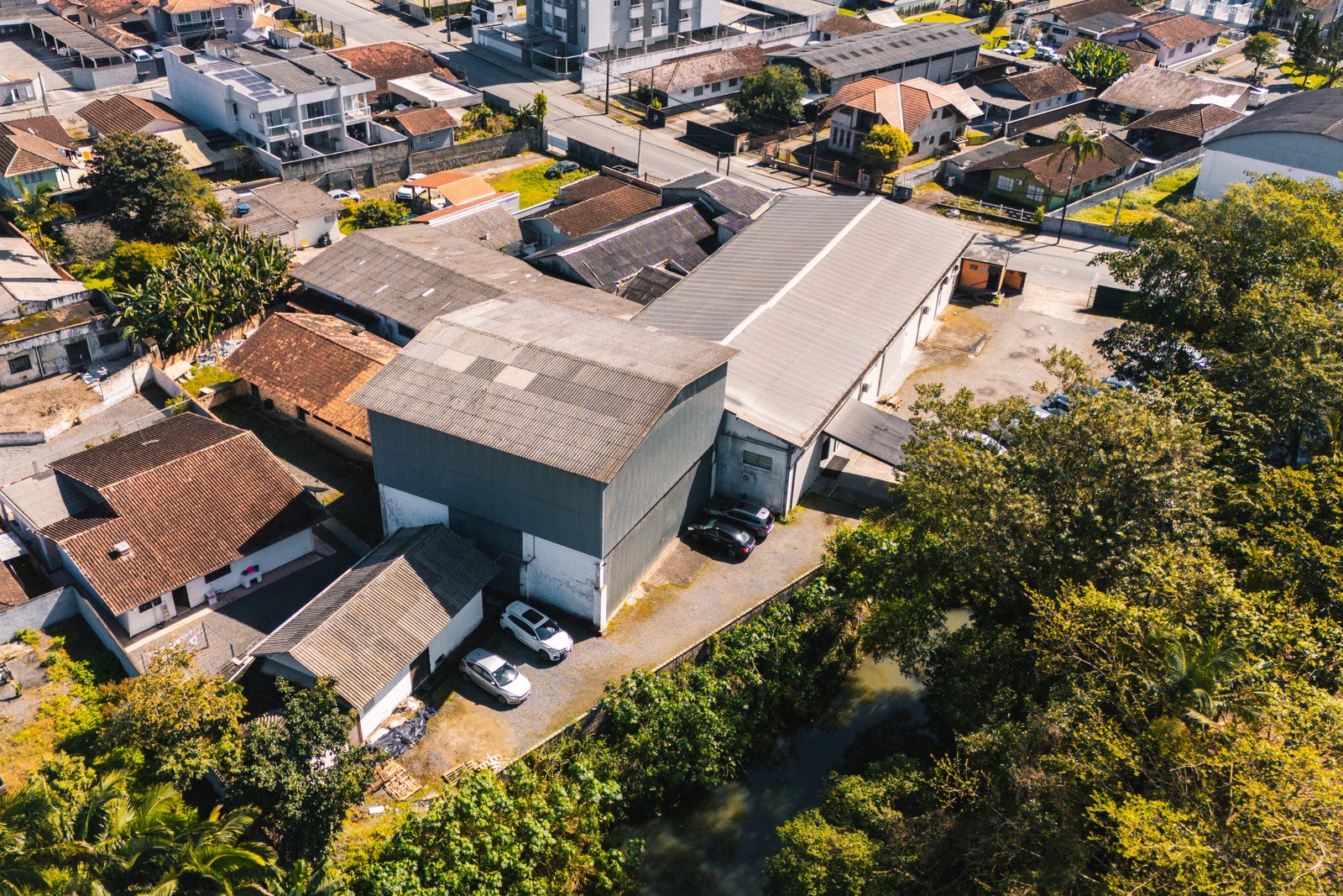 O galpão da igreja visto pelos fundos, com o estacionamento ao lado